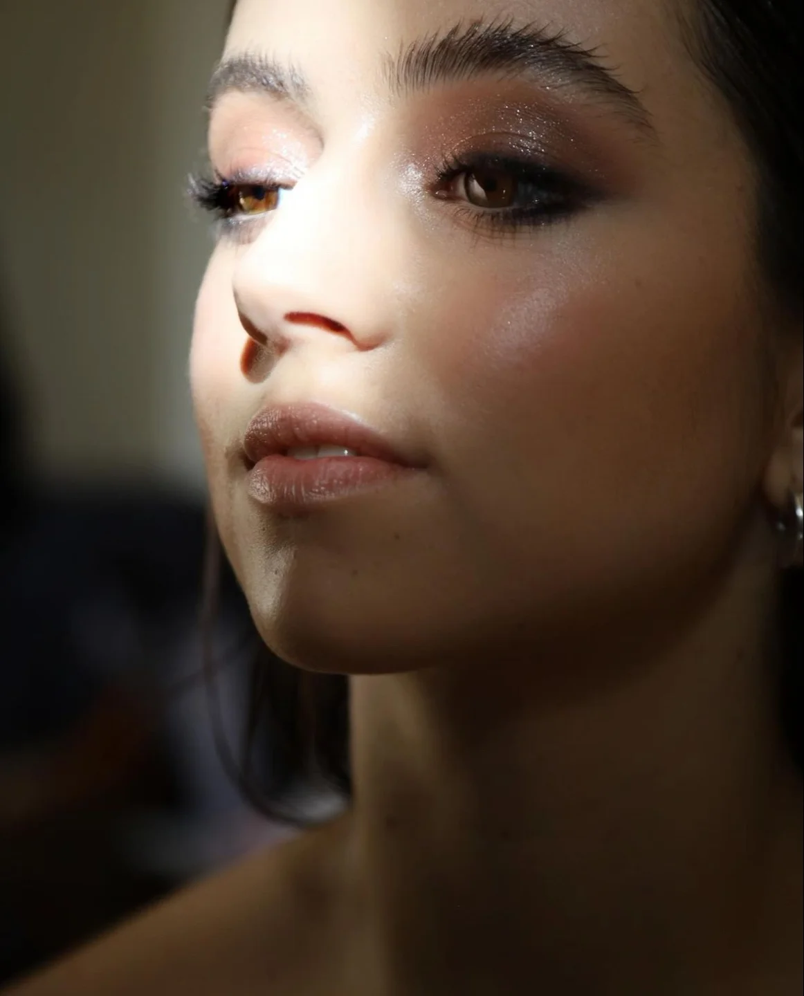 Novia sonriente poniéndose los pendientes antes de la boda